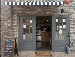 Warm and inviting coffee shop with books, wooden walls, and vintage decor